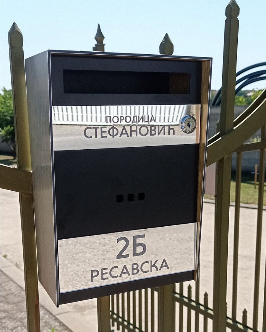 Poštansko sanduče na metalnoj ogradi, uz oznaku ulice i broja